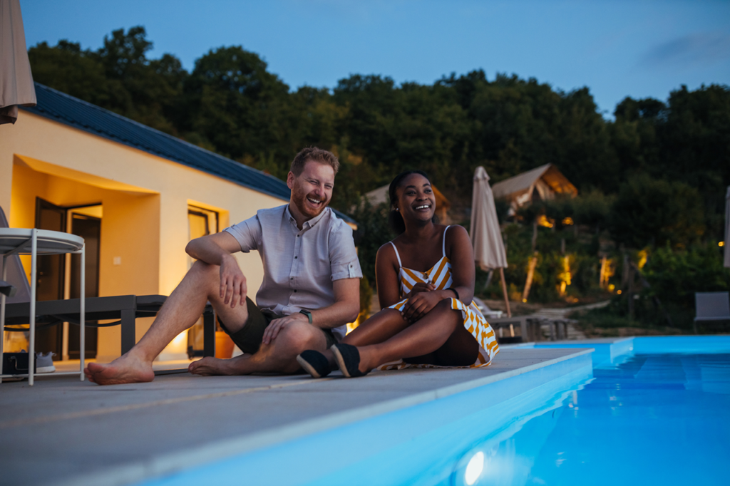 Family enjoying a sunny day by their inground pool